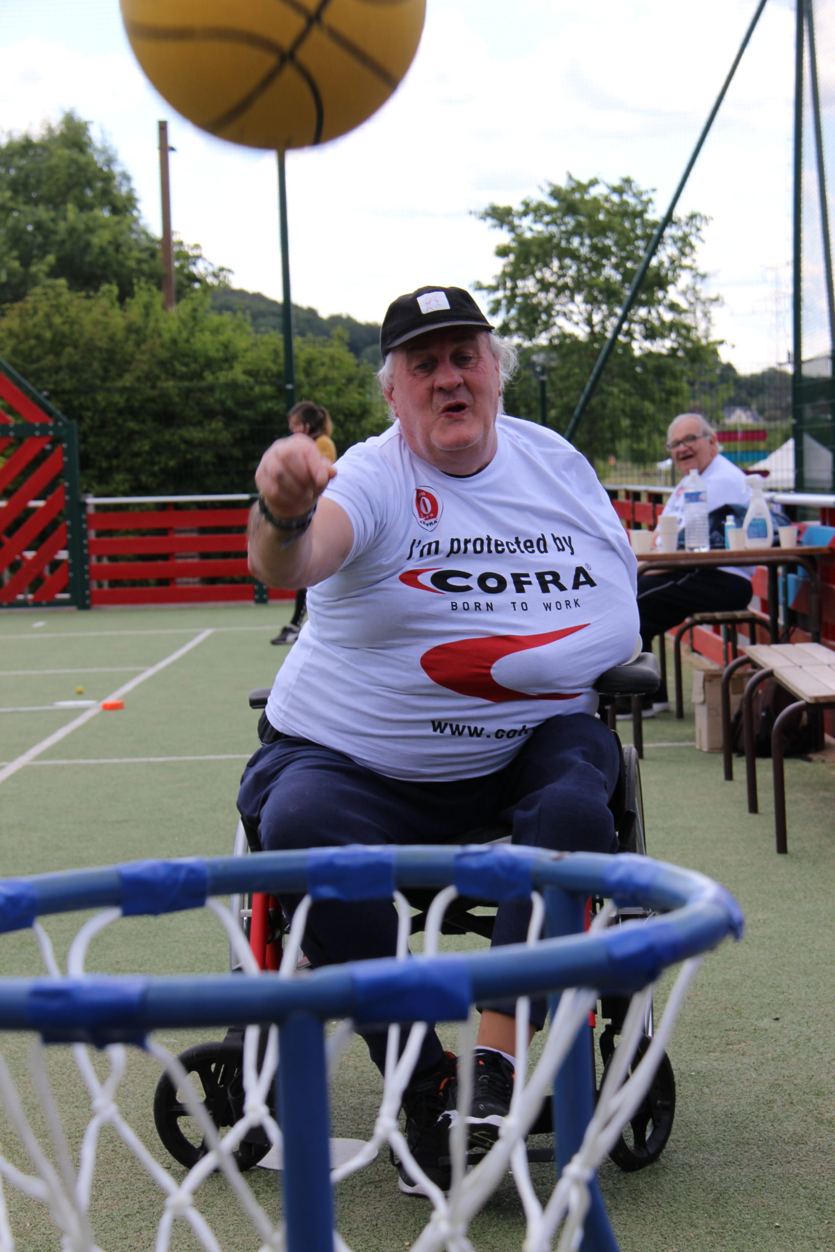 Un résident en fauteuil joue au basket lors de la journée Olympique organisées par le FAM à Bailleul sur Thérain.