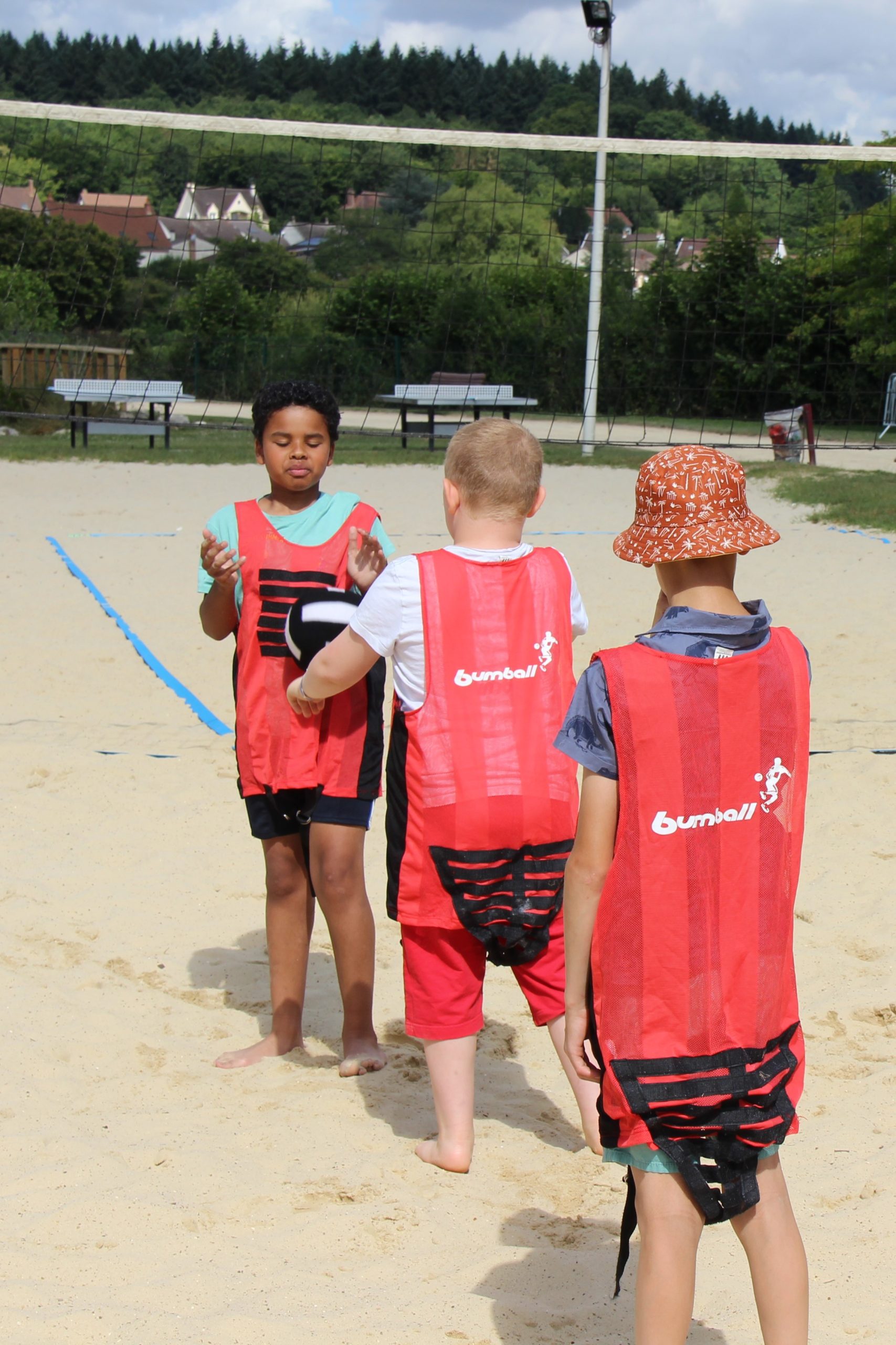 Trois enfants de l'IME Les Papillons Blancs jouent au sandball.