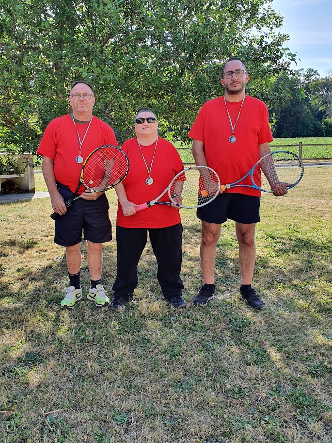 3 usagers posent avec leur raquette de tennis
