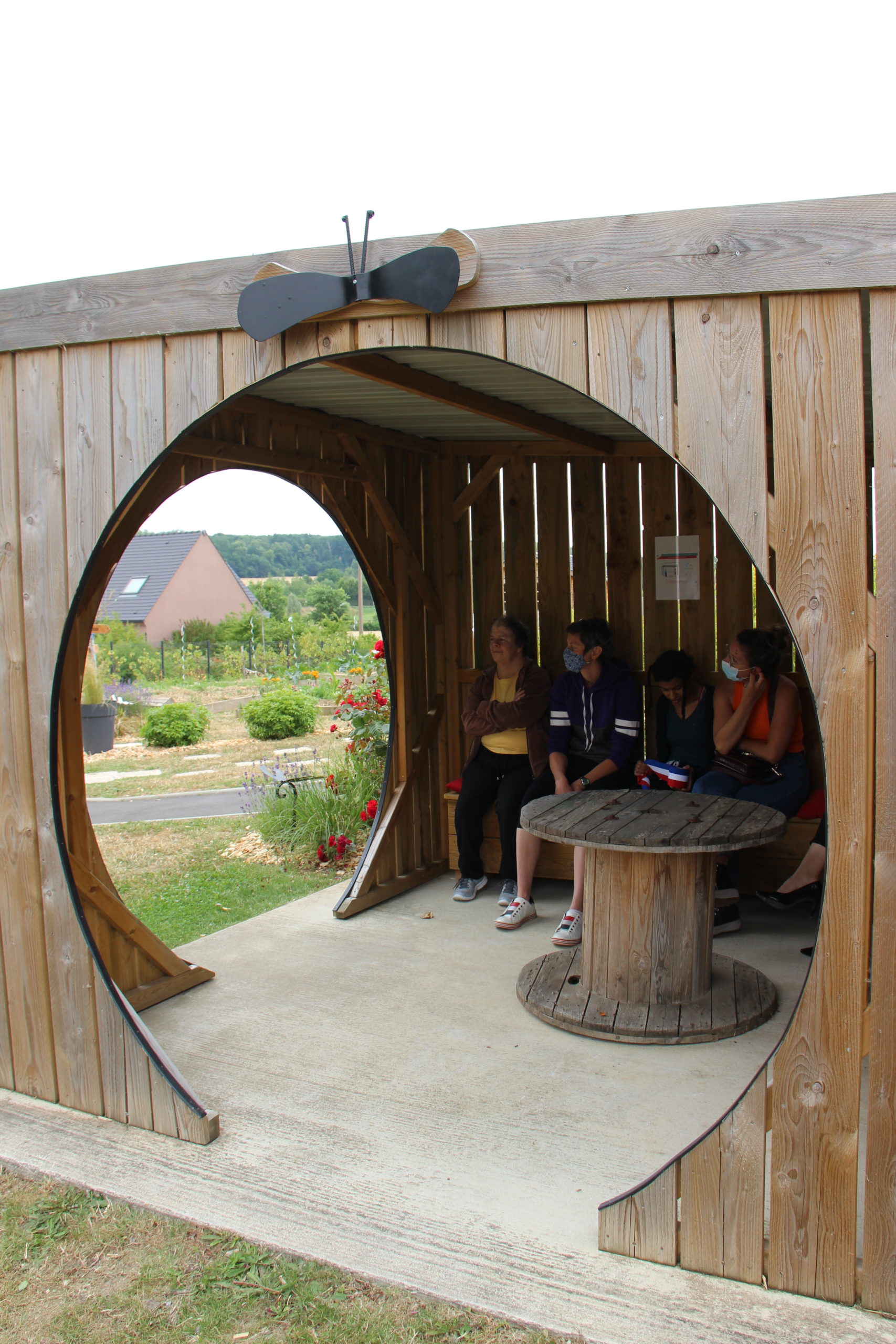 Résidents et professionnels du FAM font une pause dans une cabane du jardin sensori-moteur.