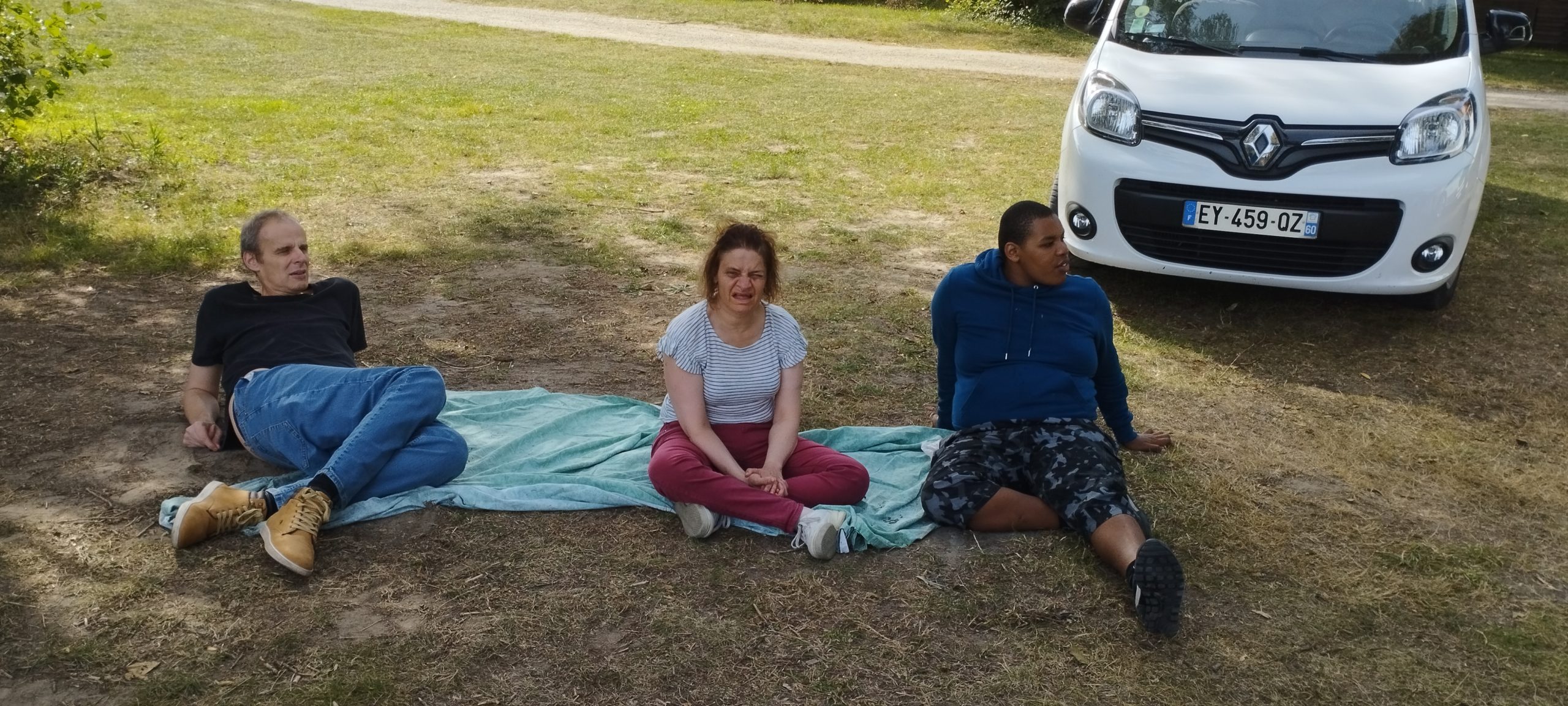 3 résidents d'Halatte se reposent dans l'herbe lors de la sortie pêche