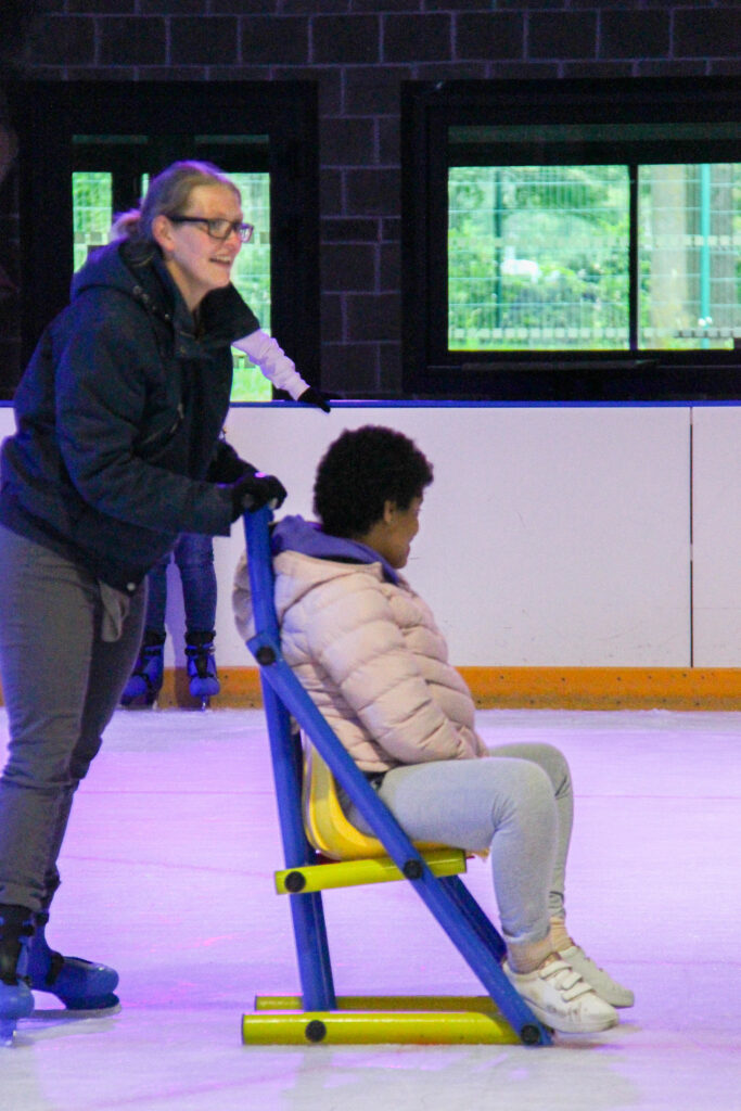 Une éducatrice pousse une jeune fille sur la glace