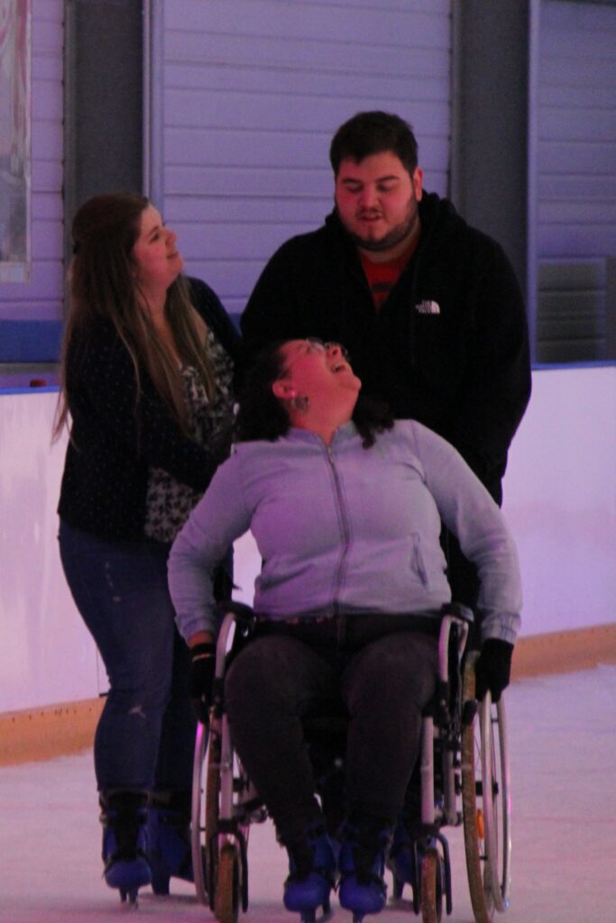 Une résidente en fauteuil roulant heureuse d'être sur la glace à la patinoire de Beauvais.