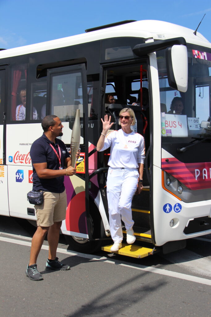 Aurélie, descends du bus des relayeurs et récupère sa torche olympique.