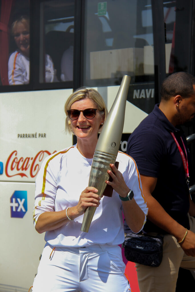 Aurélie, éducatrice sportive aux résidences du Vexin est relayeuse de la flamme olympique 2024 ! | Aurélie sourit et porte sa torche