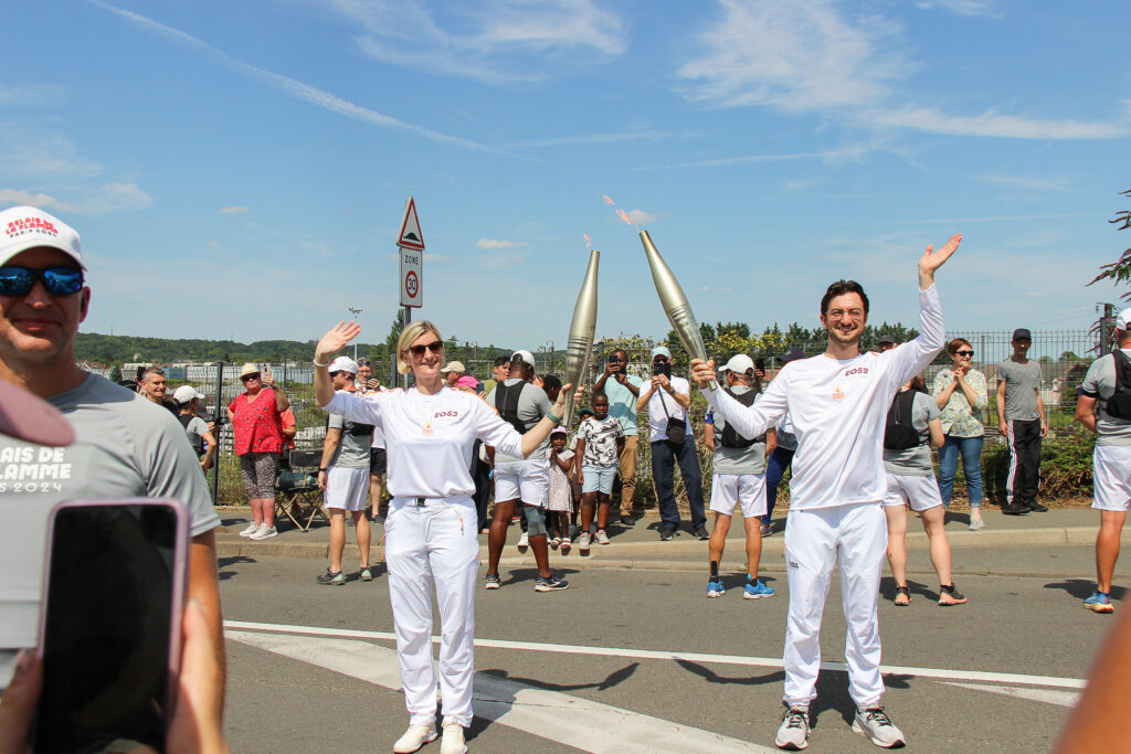 Aurélien passe le relai de la flamme olympique 2024 à Aurélie, sur le Pont Royal à Nogent sur Oise.