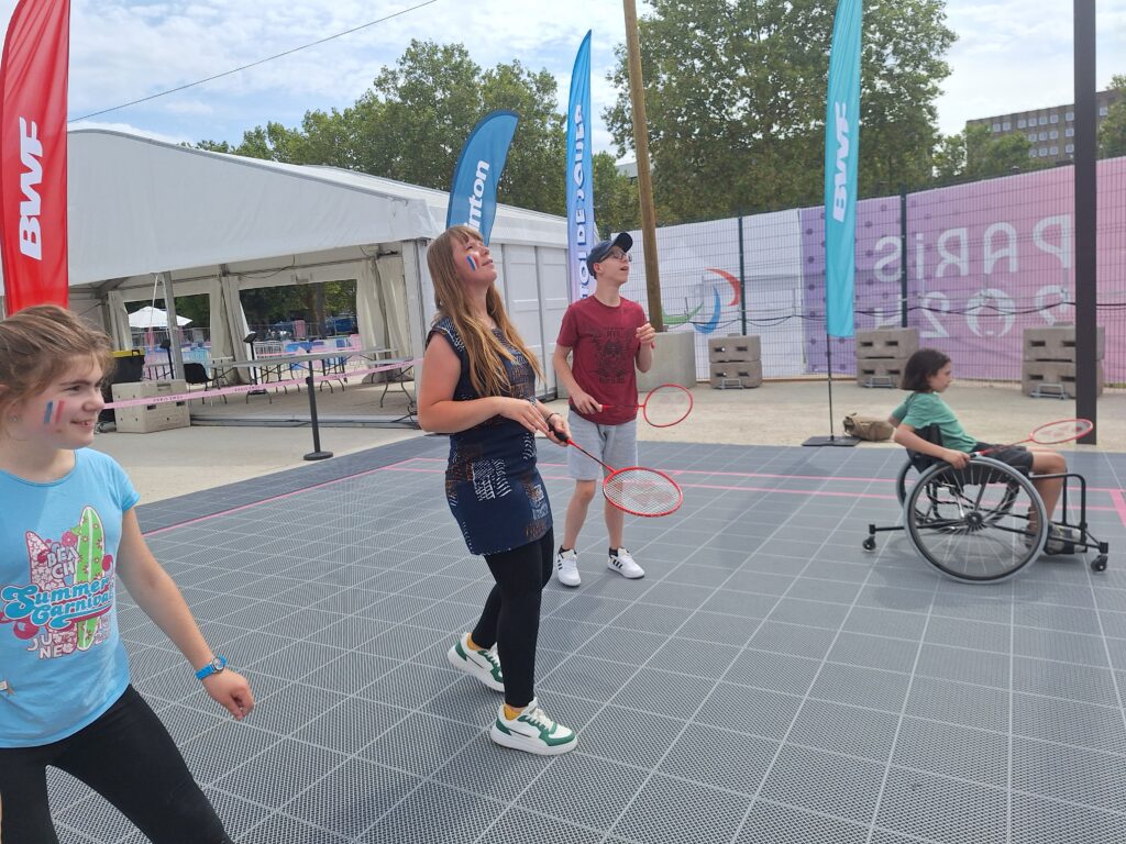 Des jeunes de l'IME Les Papillons blancs jouent au badminton dans la fan zone de Paris 2024.