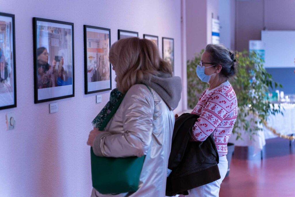 Deux personnes observent l'exposition « Regards sur le quotidien » co-créée par les résidents de La Liovette et de l'EHPAD du centre hospitalier de Beauvais.