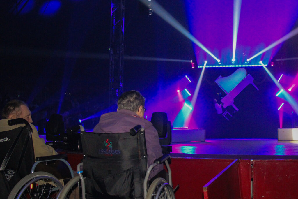 Un résident en fauteuil observe un numéro du cirque impérial show