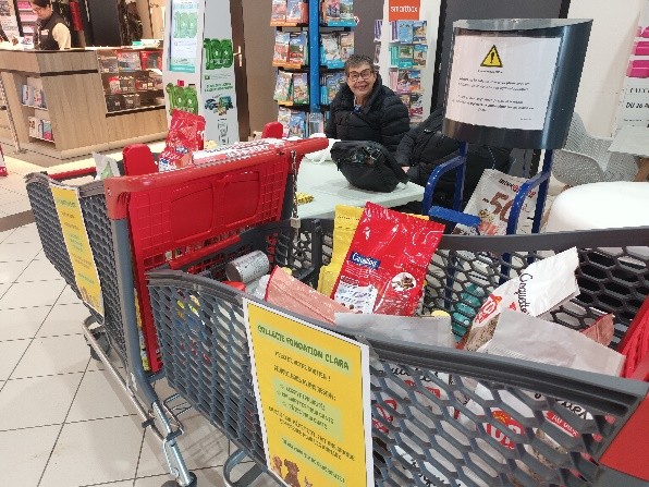 Une résidente pose fièrement avec les caddies de dons récupérés pour la Fondation Clara